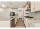 This kitchen features stainless appliances, granite counters and modern lighting fixtures over the island at 1602 Dover Creek Ln, Lawrenceville, GA 30045