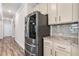 Modern kitchen with stainless steel refrigerator, granite counters, and stylish backsplash at 1602 Dover Creek Ln, Lawrenceville, GA 30045
