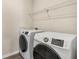 A bright laundry room features a side-by-side washer and dryer, plus wire shelving for storage at 1602 Dover Creek Ln, Lawrenceville, GA 30045