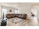 Spacious living room featuring a leather sectional sofa, rug, and wood-look flooring at 1602 Dover Creek Ln, Lawrenceville, GA 30045