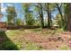 Backyard featuring a green lawn, trees, and a wooden fence in the distance at 1907 Clarke Ln, Decatur, GA 30035