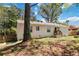 View of the backyard, showing the side of the house and green lawn with tree coverage at 1907 Clarke Ln, Decatur, GA 30035