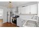 Well-lit kitchen featuring stainless appliances, white cabinets, and stylish lighting at 1907 Clarke Ln, Decatur, GA 30035