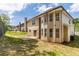 View of the rear of a two-story home with a concrete patio and fenced yard with newly planted grass at 351 Chandler Bluff Ct, Grayson, GA 30017