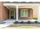 Inviting front porch featuring brick columns, manicured landscaping, and a stylish front door at 351 Chandler Bluff Ct, Grayson, GA 30017
