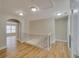 Upstairs hallway with wood flooring, neutral paint, and iron railing at 351 Chandler Bluff Ct, Grayson, GA 30017