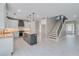 Open-concept kitchen with white cabinets, granite countertops, stainless appliances and gray center island with stairs at 351 Chandler Bluff Ct, Grayson, GA 30017