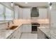 Modern kitchen with white cabinets, granite countertops, stainless steel appliances, and modern lighting fixtures at 351 Chandler Bluff Ct, Grayson, GA 30017