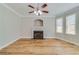Cozy living room features a fireplace, hardwood floors, modern fan, and large windows providing natural light at 351 Chandler Bluff Ct, Grayson, GA 30017