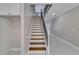 Stairway with light wood stairs, white risers, and white tile flooring at 351 Chandler Bluff Ct, Grayson, GA 30017