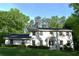Inviting two-story white brick home featuring a dark roof, shuttered windows, and lush green surroundings at 3562 Sunderland Ne Cir, Atlanta, GA 30319