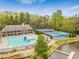 Aerial view of community pool, tennis courts, and clubhouse surrounded by trees, near a lake at 3562 Sunderland Ne Cir, Atlanta, GA 30319