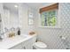 Charming powder room with patterned wallpaper, modern fixtures, and a window at 3562 Sunderland Ne Cir, Atlanta, GA 30319