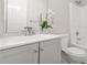 This bathroom features a white vanity with an elegant white flower display and a shower/tub combo at 3927 Villager Way, Rex, GA 30273