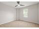Neutral bedroom boasts plush carpet, a ceiling fan, and natural light at 3927 Villager Way, Rex, GA 30273
