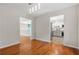 Dining room showcasing newly finished hardwood floors, modern lighting and entry to a remodeled kitchen at 3927 Villager Way, Rex, GA 30273