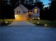 A charming two-story home with landscaped yard is seen at nighttime at 3927 Villager Way, Rex, GA 30273