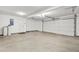 This clean garage features white walls, grey floors, and a large garage door at 3927 Villager Way, Rex, GA 30273