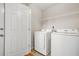 This laundry room includes a washing machine and dryer along with wire shelving for storage at 3927 Villager Way, Rex, GA 30273