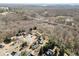 Aerial view of neighborhood featuring a lush tree canopy, winding roads, and waterfront in distance at 7430 Valley Landing Ct, Cumming, GA 30041