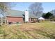 Wide backyard features a well-maintained lawn, red brick exterior, and wooden fence at 7430 Valley Landing Ct, Cumming, GA 30041