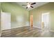 Large bedroom featuring hardwood flooring, neutral walls, and multiple entry doorways at 7430 Valley Landing Ct, Cumming, GA 30041