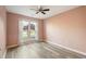 Bedroom with soft pink walls, a window, and luxury vinyl plank flooring at 7430 Valley Landing Ct, Cumming, GA 30041
