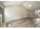 Open living room space showcasing a fireplace and vaulted ceilings with wood flooring at 7430 Valley Landing Ct, Cumming, GA 30041