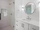 Bathroom showcasing frameless glass shower, quartz counters, a circular mirror and modern light fixtures at 819 Loridans Ne Dr, Atlanta, GA 30342
