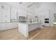 Spacious kitchen featuring a large center island with a sink, modern cabinetry, stone countertops, and stainless steel appliances at 819 Loridans Ne Dr, Atlanta, GA 30342