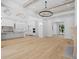 Open-concept living area boasts hardwood floors, a fireplace, and an adjacent modern kitchen with an oversized light fixture at 819 Loridans Ne Dr, Atlanta, GA 30342