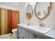 Cozy bathroom with decorative tile flooring, unique mirrors, and a colorful shower curtain at 1326 Janmar Rd, Snellville, GA 30078