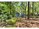 View of the blue house from a wooded area highlighting its natural surroundings at 1326 Janmar Rd, Snellville, GA 30078
