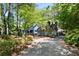 Charming blue house with mature trees, a driveway, and a brick chimney at 1326 Janmar Rd, Snellville, GA 30078