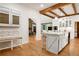 Bright kitchen with white cabinets, light wood floors, stainless steel appliances and an adjacent living space at 1326 Janmar Rd, Snellville, GA 30078