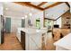 Bright kitchen with white cabinets, stainless steel appliances, light wood floors and adjacent living space at 1326 Janmar Rd, Snellville, GA 30078