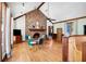 Cozy living room with a brick fireplace, wooden floors and ceiling beams with lots of light from large windows at 1326 Janmar Rd, Snellville, GA 30078