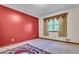 Bedroom featuring a red accent wall, vintage carpet, and large window at 9082 Chestnut Lake Dr, Jonesboro, GA 30236