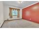 Bedroom featuring a large window with decorative valances and a red accent wall at 9082 Chestnut Lake Dr, Jonesboro, GA 30236