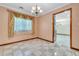 Dining room with chandelier, tiled floor, and elegant draperies providing natural light at 9082 Chestnut Lake Dr, Jonesboro, GA 30236