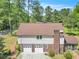 Rear exterior view of house with two-car garage, chimney, and partially covered porch at 9082 Chestnut Lake Dr, Jonesboro, GA 30236