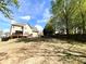 Spacious backyard with mature trees, lush grass, and a beautiful view of the home at 2585 Chandler Grove Dr, Buford, GA 30519