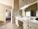 Bright bathroom featuring double sinks with white cabinets and a large mirror reflecting the shower at 2585 Chandler Grove Dr, Buford, GA 30519