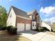 Two-story brick and siding home with a two-car garage, complemented by well-kept landscaping and a paved driveway at 2585 Chandler Grove Dr, Buford, GA 30519
