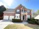 Stunning two-story brick home featuring a two-car garage, complemented by lush greenery and a manicured lawn at 2585 Chandler Grove Dr, Buford, GA 30519