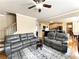 Spacious living room flows into the kitchen, with hardwood floors, leather furniture, and ceiling fan at 2585 Chandler Grove Dr, Buford, GA 30519