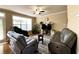 Living room features hardwood floors, leather furniture, large window and views of the yard at 2585 Chandler Grove Dr, Buford, GA 30519