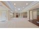 Finished basement showcasing neutral carpet, a cozy fireplace, wet bar area, and a tray ceiling with recessed lighting at 4250 Harrison Lndg, Cumming, GA 30041