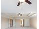 An empty bedroom with neutral walls, neutral carpet, tray ceiling, ceiling fan, and open doorways at 4250 Harrison Lndg, Cumming, GA 30041