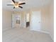 An empty bedroom with neutral walls, neutral carpet, ceiling fan, and open doorways at 4250 Harrison Lndg, Cumming, GA 30041
